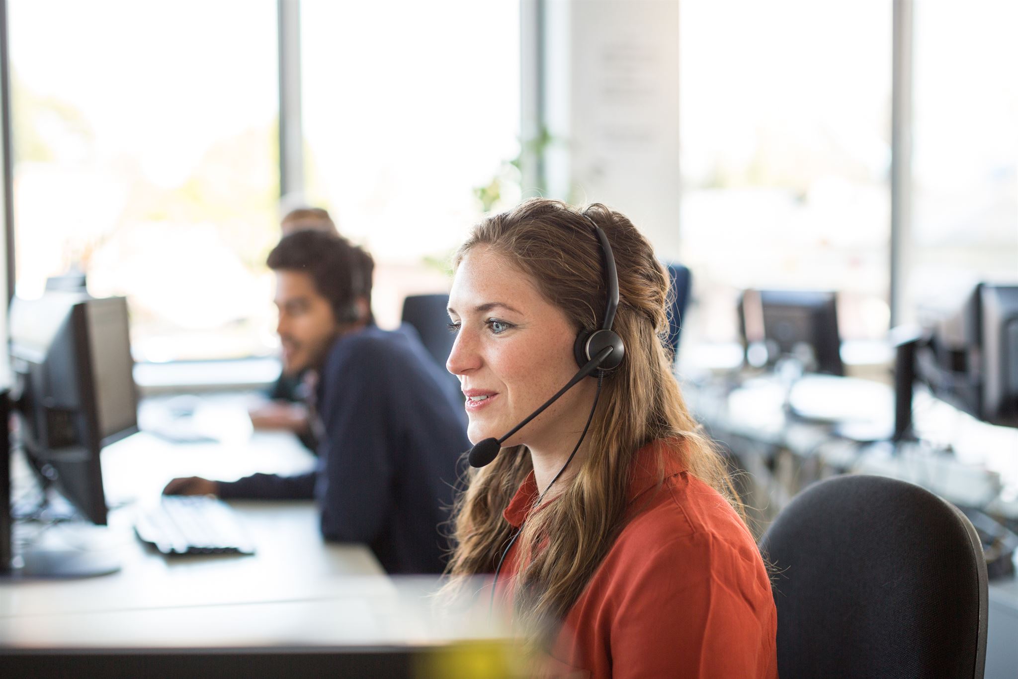 Person using headset in a busy office